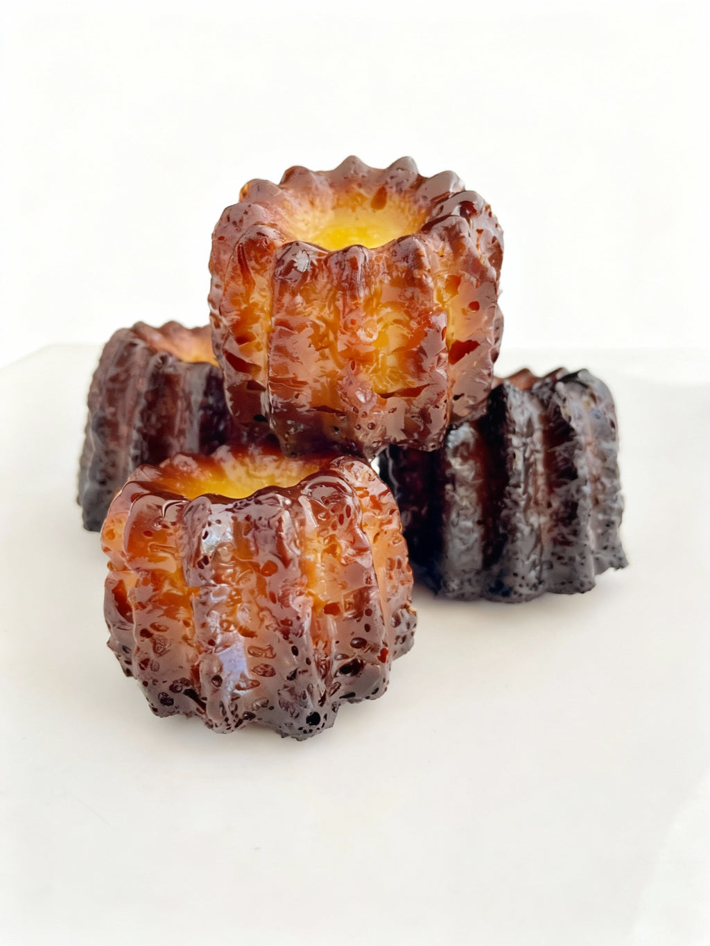 Authentic French canelés with caramelized crust and vanilla rum custard heart, handmade in Venice Florida by French Atelier, French bakery.
