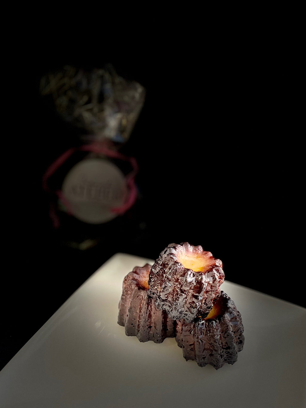Authentic French canelés with caramelized crust and vanilla rum custard heart, handmade in Venice Florida by French Atelier, French bakery.